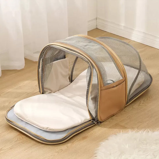 Extension en filet déployée d'un sac a dos pour chien beige posé sur un parquet.