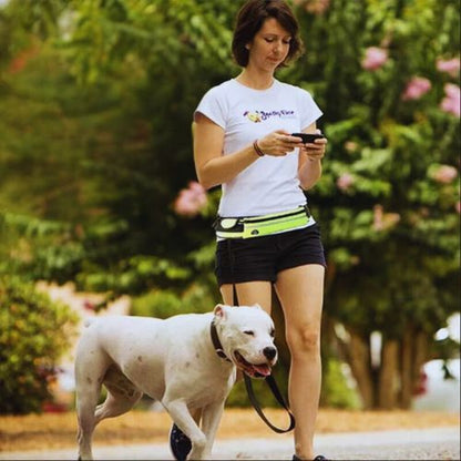 Laisse pour chien : Elle promène sont pitbull en manipulant aisément son téléphone grâce à la  laisse main libre de couleur noir et vert fluo