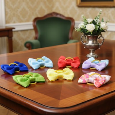 Assortiment de sept modèles colorés de noeud papillon chien posés sur une table en bois de bureau.