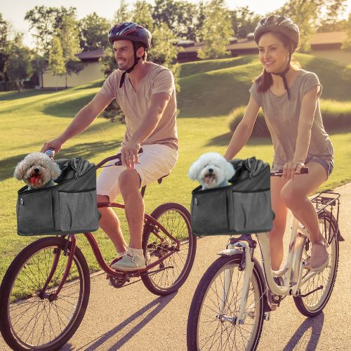 Couple en balade cycliste utilisant chacun un panier velo chien pour transporter leurs animaux.