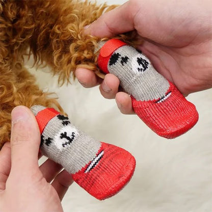 Gros plan sur des chaussures chien en tricot gris et rouge avec semelle texturée.