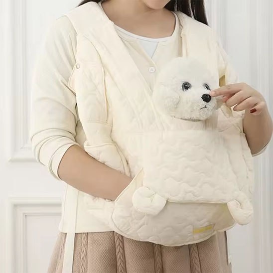 Zoom sur un sac de transport blanc pour chien avec poches latérales et petit chien blanc.