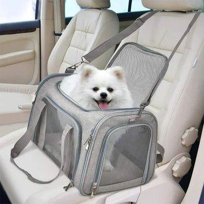 Sac de transport pour chien gris avec un Spitz blanc installé sur le siège passager.