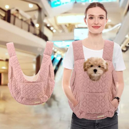Petit chien dans un sac de transport rose a motif matelasse, porte par une femme.