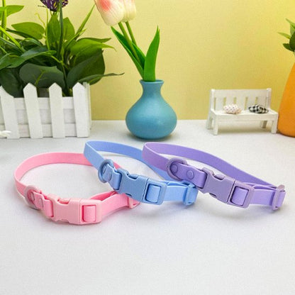 Collier pour chien en PVC rose, bleu et lavande. Gros plan sur les boucles de fermeture en plastique. Produit imperméable, facile à nettoyer et résistant.