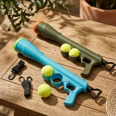 Deux modèles de lanceur de balle pour chien, bleu et vert, avec leurs sangles de transport.