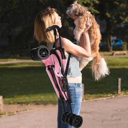 Femme portant une poussette pour chien rose pliée sur l'épaule tout en tenant son Shih Tzu.