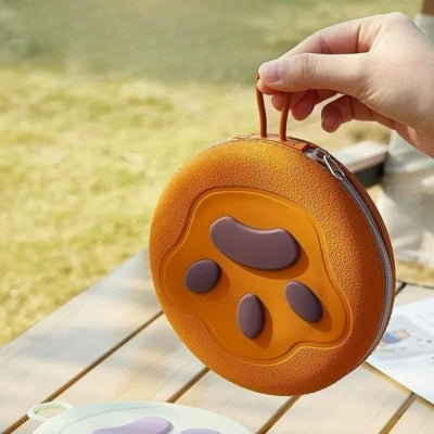 Gros plan sur l'étui de transport orange rigide des gamelles chien avec relief de patte.