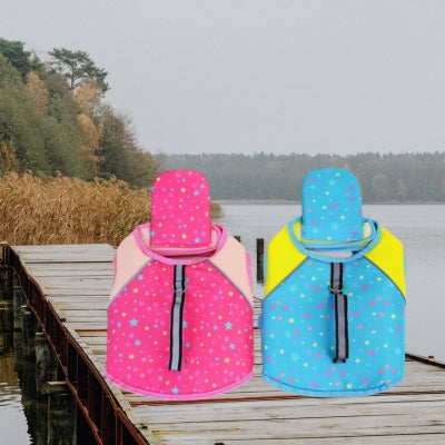 Deux modèles de gilet de sauvetage pour chien, rose et bleu, posés sur un ponton en bois.