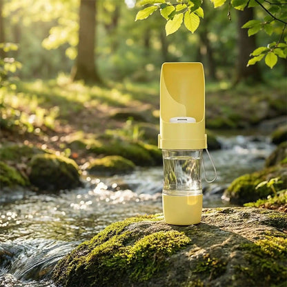 Gourde pour chien jaune posée sur un rocher moussu devant une rivière.