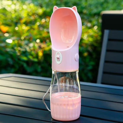 Gourde pour chien rose avec oreilles de chat posée sur une table de jardin sombre.