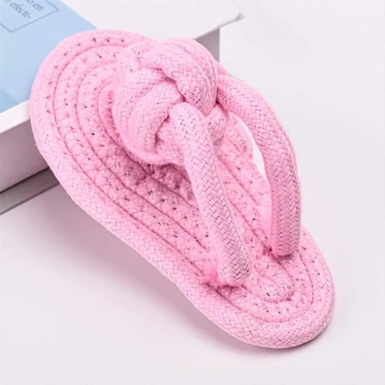Gros plan d'un jouet pour chiens en corde tressée rose pastel en forme de tong.