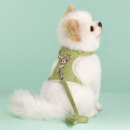 Petit chien de type Spitz portant un harnais chien vert pastel avec motif ours