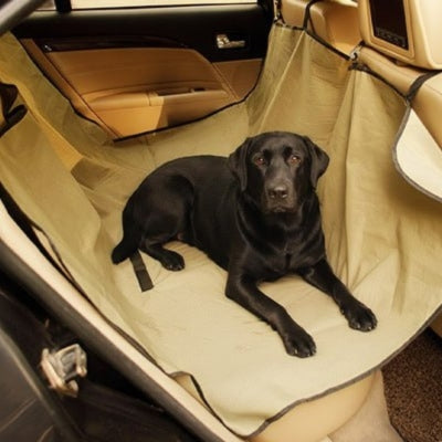Labrador noir couché sur une housse protection voiture chien beige en forme de hamac.