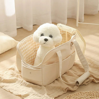 Sac de transport pour chien-ChicStroll™ : Ce caniche nain est confortablement assis dans un sac de transport de couleur blanche posé sur le parquet du salon