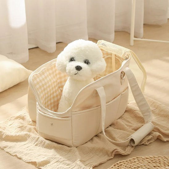 Intérieur à carreaux d'un sac de transport pour chien ouvert avec une peluche blanche.