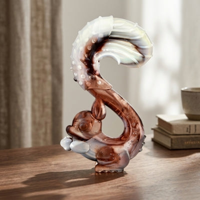 Jouet chien indestructible en forme d'écureuil stylisé posé sur un bureau près de livres.