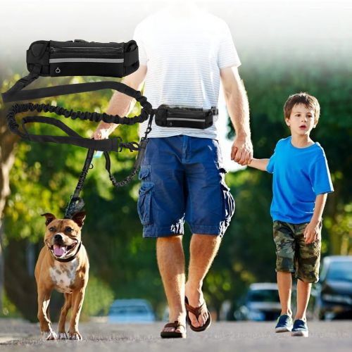 Ce monsieur se promène avec son fils tout en baladant son chien grâce à cette laisse pour chien main libre de couleur noir.