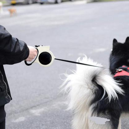 Personne de profil utilisant une laisse pour chien blanche rétractable pour promener un chien noir.