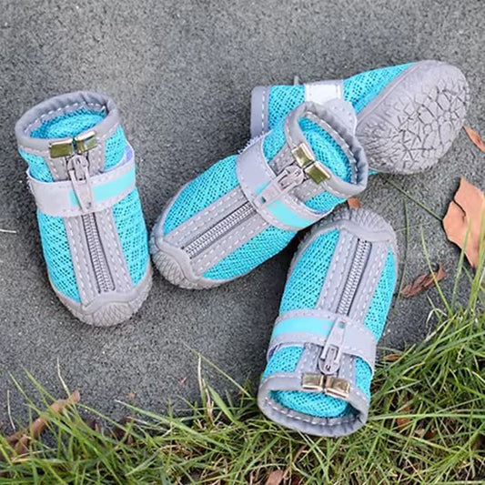 Vue de dessus de quatre chaussure chien bleues en maille avec fermetures éclair sur le sol.