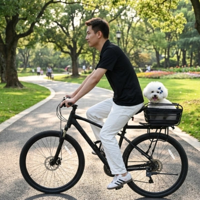 Homme à vélo avec un Bichon frisé dans un panier pour velo chien central sur une allée de parc.