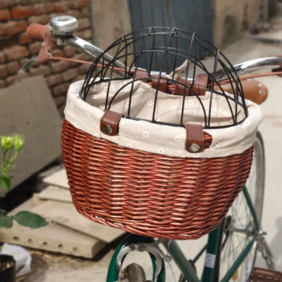 Vue rapprochée d'un panier pour vélo chien en osier vide avec sa grille fermée.