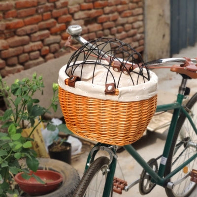 Panier pour vélo chien en osier vide avec grille de protection, monté sur un vélo vert.