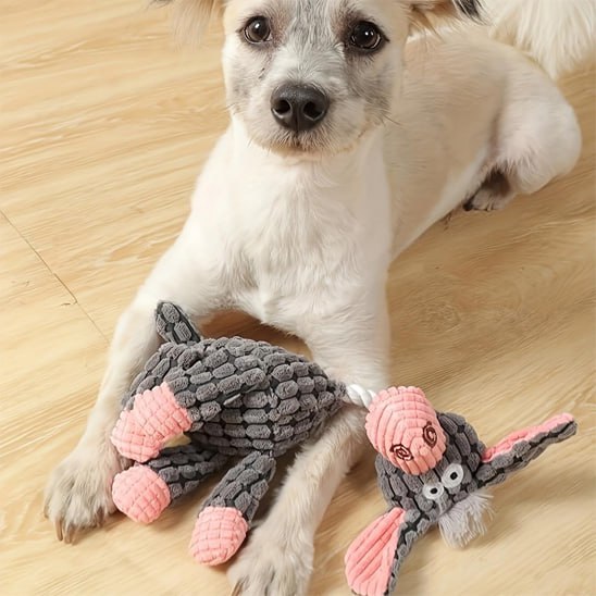 Chiot couché près d'une peluche pour chien grise en forme d'âne à texture côtelée.