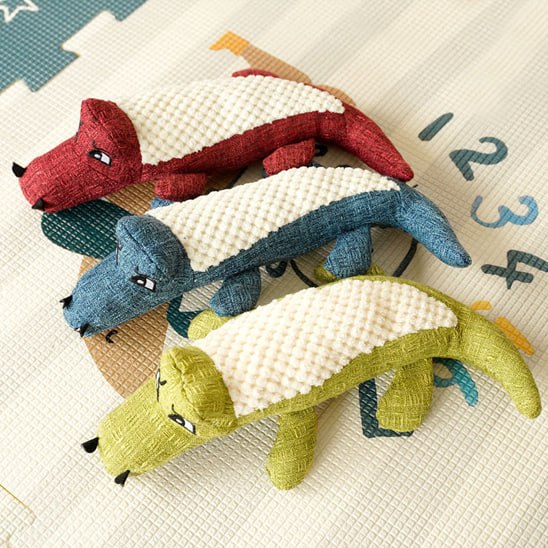 Trois modèles de peluche pour chien crocodile sur un tapis avec les chiffres 1, 2, 3 et 4.
