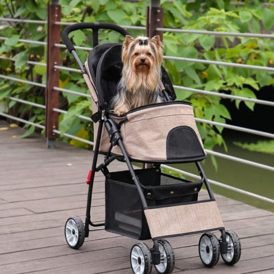 Yorkshire Terrier assis dans l'une des poussettes pour chiens beige sur un pont en bois.