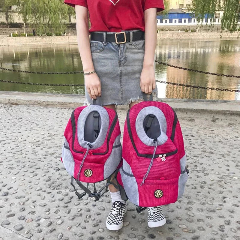 Femme tenant deux modèles de sac à dos chien fuchsia et gris au bord de l'eau.