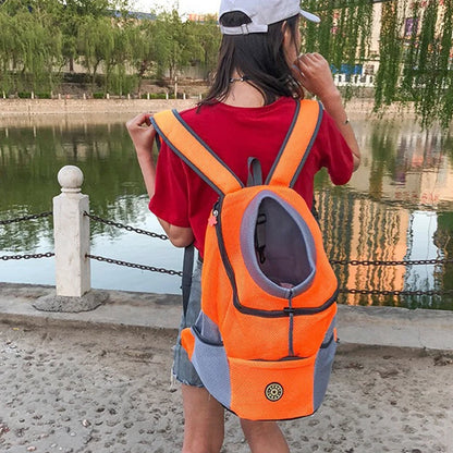 Vue arrière d'une femme portant un sac à dos chien orange et gris avec ouverture ronde.