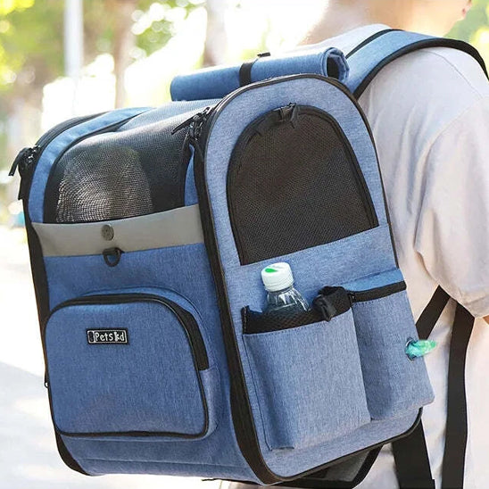 Détail d'un sac a dos pour chien bleu porté avec bouteille d'eau et distributeur de sacs.