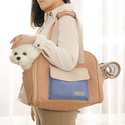 Femme portant à l'épaule un sac a dos pour chien beige et bleu avec un Bichon Frisé.