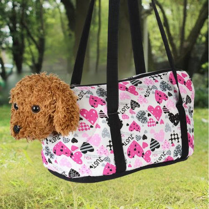 Sac de transport chien cœurs roses porté à l'épaule avec un petit chien Caniche marron.