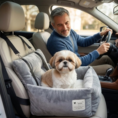 Un Shih Tzu dans un siege auto chiens gris avec l'étiquette POOM, un homme conduit.