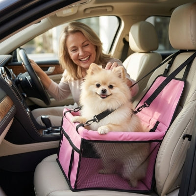 Loulou de Poméranie blanc dans un siege auto pour chien rose sur le siège passager.