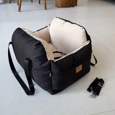 Modele de siege auto pour chiens noir avec intérieur crème et accessoires de fixation.