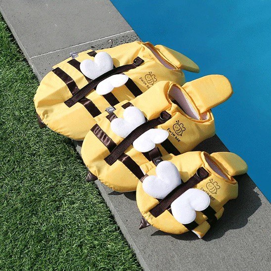 Trois tailles du gilet de sauvetage pour chien Swim Bee posées au bord d'une piscine.