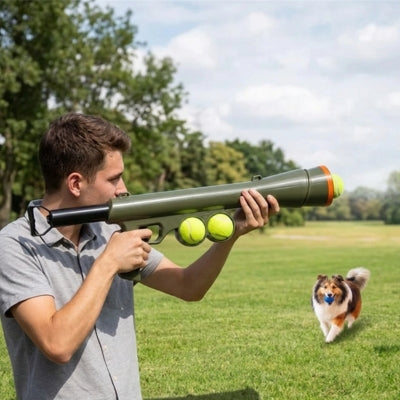 Homme visant avec un lanceur de balle pour chien face à un Berger des Shetland au loin.