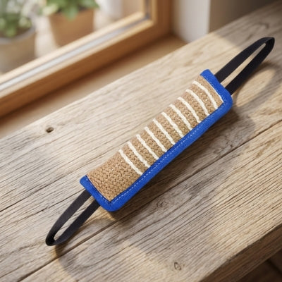 Zoom sur un jouet pour chien indestructible bleu en toile de jute posé sur un rebord en bois.